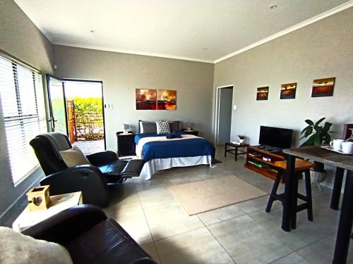 a bedroom with a bed and a tv in a room at Silver Oaks Airbnb in Langebaan