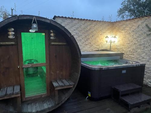 a circular bath tub with a green door and stairs at Casa Dudu in Moieciu de Jos