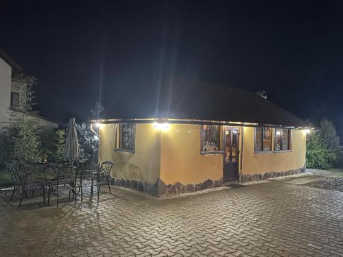 a yellow building with a table and chairs at night at Casa Dudu in Moieciu de Jos