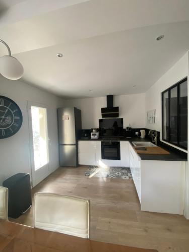 une cuisine avec des armoires blanches et un comptoir dans l'établissement Maison la Londe, à La Londe-les-Maures