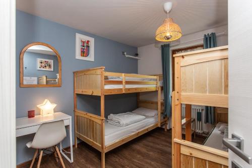 a room with two bunk beds and a desk and a lamp at La casa di Matilde - trilocale vicinissimo alle piste da sci in La Thuile