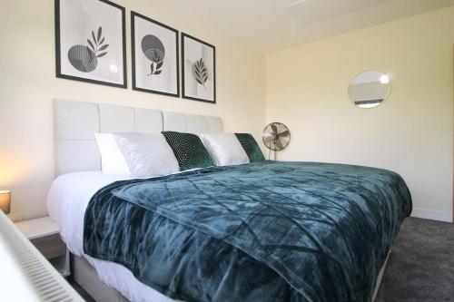 a bedroom with a large bed with a blue comforter at Cosy Modern 3 Bedroom House in Bradford City in Wibsey