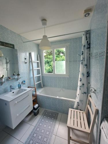 un bagno con vasca, lavandino e vasca da bagno di logement avec jardin de bord Mer PORT NAVALO ad Arzon