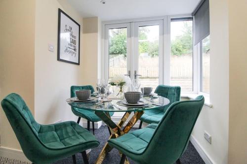 a dining room with a table and green chairs at Cosy Modern 3 Bedroom House in Bradford City in Wibsey