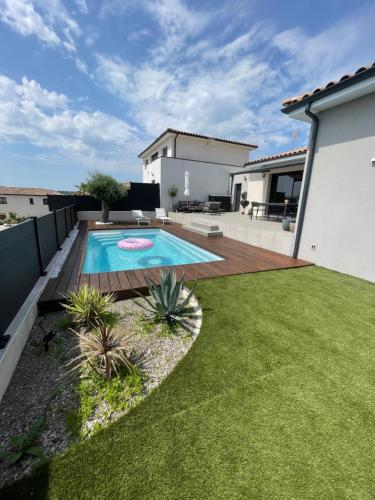 a backyard with a swimming pool and grass at Maison individuelle in Combaillaux