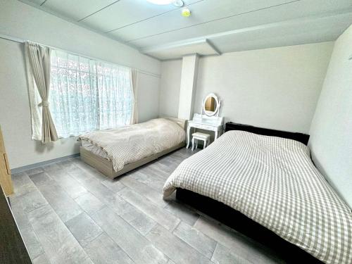 a bedroom with two beds and a table with a mirror at KOBAYASHi 東京 in Tokyo