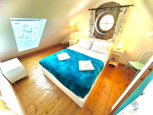a bedroom with a large bed with a blue blanket at DRIFTWOOD - Super 1 Bedroom Home with Sea Views in Saint Levan