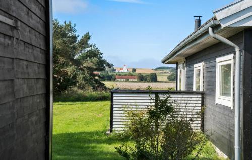a house with a fence next to a field at 3 Bedroom Beautiful Home In Samsø in Nordby