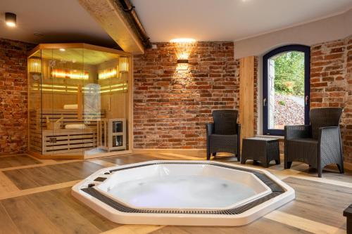 a hot tub in a room with a brick wall at Villa na pagórku Limanowa in Mordarka
