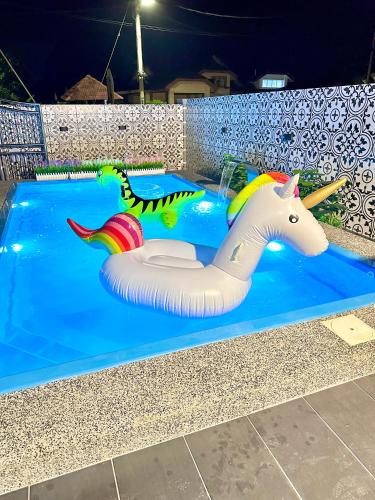 a inflatable unicorn float in a pool at night at The Cozy Home with container house 5BR 20pax in Kampong Jelutong