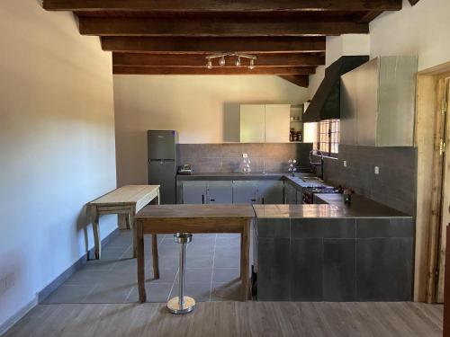 una grande cucina con un tavolo di legno di RHV Guest House a Ivato