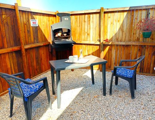 a patio with a table and two chairs and a grill at Silver Oaks Airbnb in Langebaan