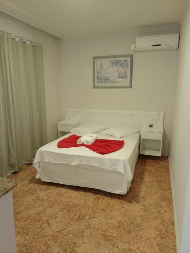 a bedroom with a bed with a teddy bear on it at Hotel Pousada Ilha do Mar Bombinhas in Bombinhas