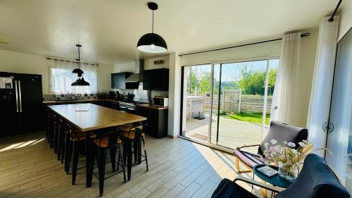 une cuisine avec une table et des chaises ainsi qu'une grande fenêtre dans l'établissement Villa 5 chambres entre mer et forêt, à Merlimont