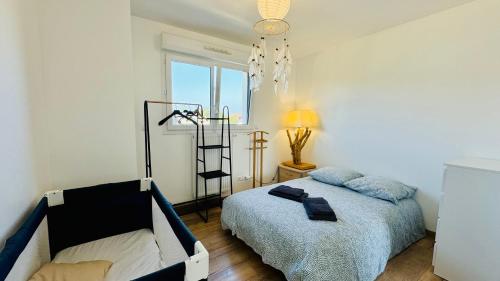 una camera da letto con un letto, una lampada e una finestra di Villa 5 chambres entre mer et forêt a Merlimont-Plage