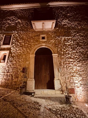a brick building with a wooden door on it at Le Camere dell’Emiro in Castronuovo di Sicilia