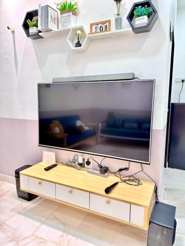 a large flat screen tv sitting on top of a table at The Cozy Home with container house 5BR 20pax in Kampong Jelutong