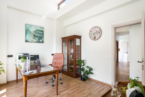 an office with a desk and a chair and a clock at Beachfront Villa Atalandia with Heated Pool, Gym, BBQ & Office in Goúdhouros