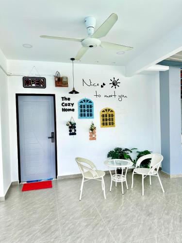 a room with a table and chairs and a wall with writing at The Cozy Home with container house 5BR 20pax in Kampong Jelutong