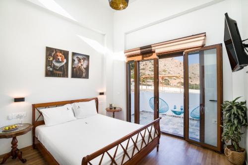 a bedroom with a bed and a view of a pool at Beachfront Villa Atalandia with Heated Pool, Gym, BBQ & Office in Goúdhouros
