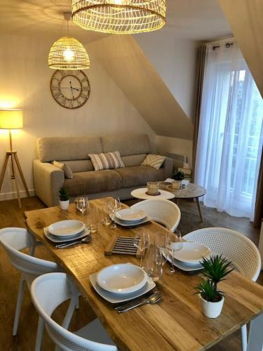 - une table à manger avec des chaises, une table et un canapé dans l'établissement Les toits de Nazado - 2-4 personnes, à Erquy