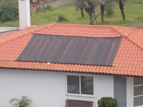 a house with an orange roof with a solar panel at Condomínio Residencial Mar Azul in Imbituba