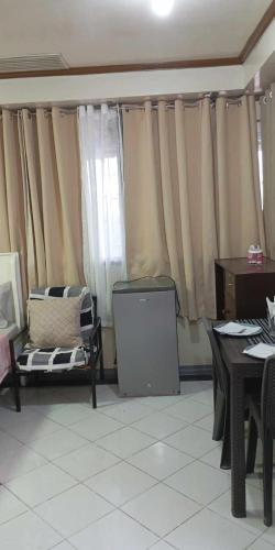 a living room with curtains and a table and chairs at De Hagan Transient Baguio City in Baguio