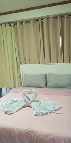 a bed with two towels in the shape of a heart at De Hagan Transient Baguio City in Baguio