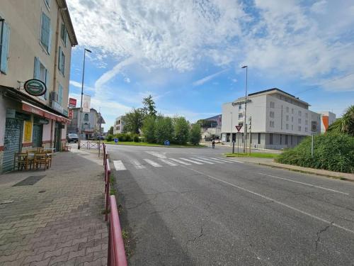 Une rue vide dans une ville avec une clôture dans l'établissement Gîte de la Tour, à Alès