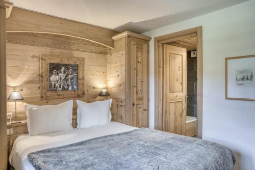a bedroom with a white bed and wooden walls at Harmonie in Demi-Quartier