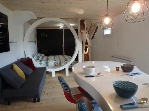 - un salon avec une table, un canapé et un miroir dans l'établissement Appartement sur les hauteurs de Mercury, à Mercury