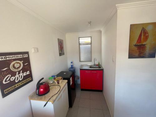 a kitchen with a sink and a red cabinet at Herradura Sur Oriente in Coquimbo
