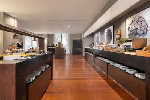 Un restaurante con una larga fila de buffet con platos en Dolce by Wyndham Barcelona Resort, en Sant Esteve Sesrovires