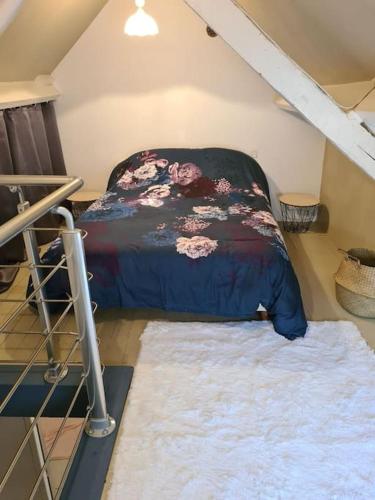 Cette petite chambre mansardée comprend un lit et un tapis. dans l'établissement Confortable maison à la campagne, à Les Fougères