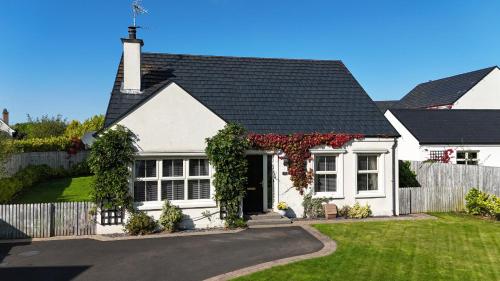 a white house with a black roof at Plantation Drive - Home from home in Limavady