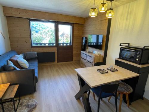 un salon avec un canapé bleu et une table dans l'établissement Studio 4 pers. à Samoëns, proche centre avec balcon, parking et casier à skis - FR-1-629-122, à Samoëns