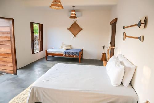 a bedroom with a white bed and a table at Villa Caju Atins in Barreirinhas