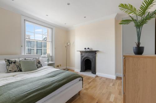 a bedroom with a large bed and a fireplace at Parea Living - Spacious 4 Story House, Families, Big Groups in London