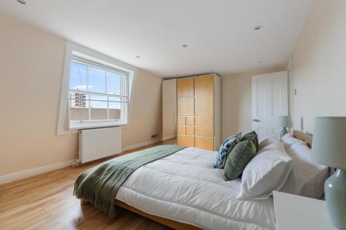a bedroom with a large bed and a window at Parea Living - Spacious 4 Story House, Families, Big Groups in London
