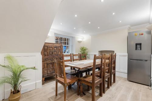 a dining room with a table and a refrigerator at Parea Living - Spacious 4 Story House, Families, Big Groups in London