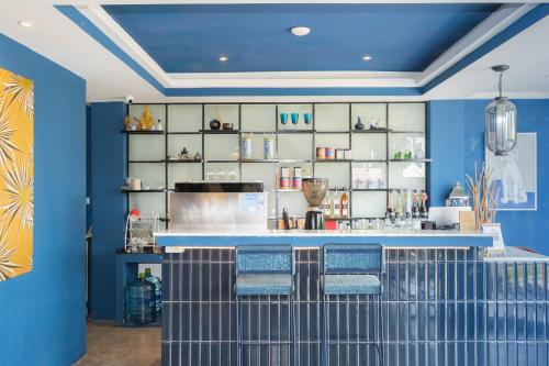 a blue room with a bar with blue walls at KRAAM Silhouette Hotel and Cafe Phuket in Chalong 