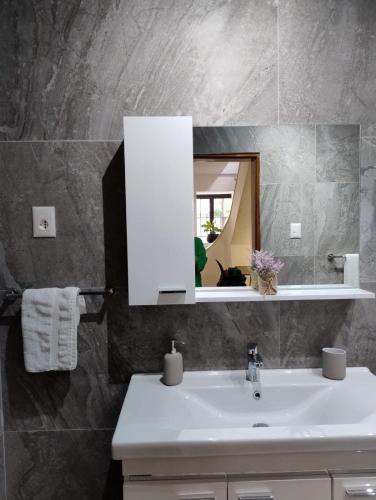 a bathroom with a white sink and a mirror at Vila Kurti in Vlorë