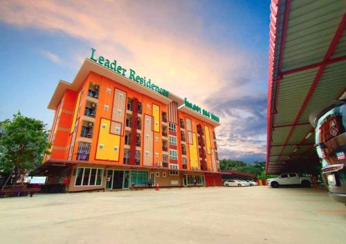 an orange building with a sign on top of it at Leader Residences - ลีดเดอร์ เรสซิเดนซ์ in Ban Thap Nang
