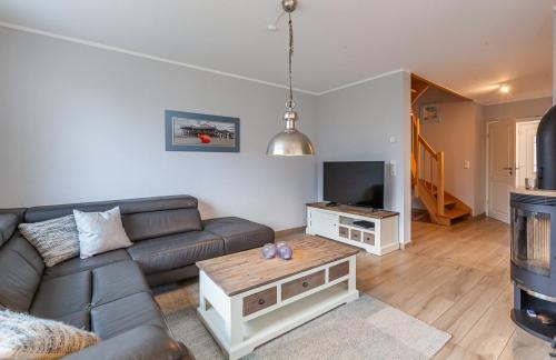 un soggiorno con un divano e una TV di Seelöwe a Zingst