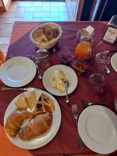 a table with plates of pastries and a basket of bread at Agriturismo Roccamaia in Pievebovigliana