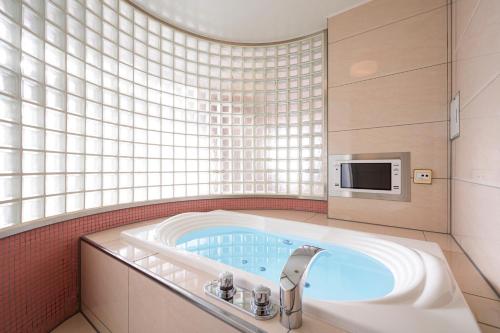 a bathroom with a bath tub with a microwave at コスタリゾート茅ヶ崎大人専用 in Suka