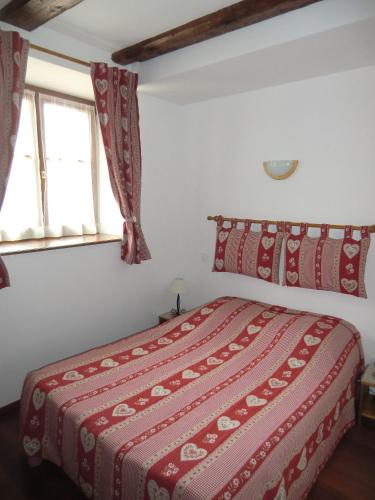 - une chambre avec un lit doté d'une couette rouge et 2 fenêtres dans l'établissement Gite Riesling, à Colmar