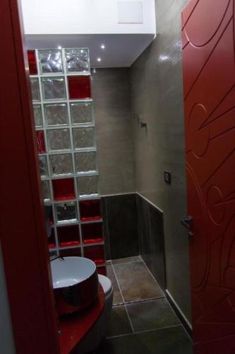 a bathroom with a toilet and a red door at RM1H in Turin