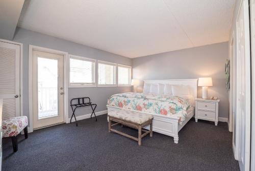 a bedroom with a bed and a chair and a window at Biscayne Suites in Ocean City