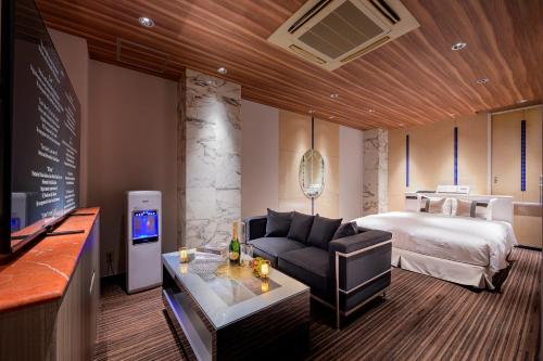 a hotel room with a bed and a couch at コスタリゾート茅ヶ崎大人専用 in Suka